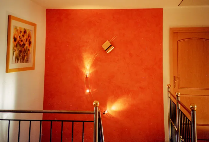 Treppenhaus mit orangefarbener Akzentwand